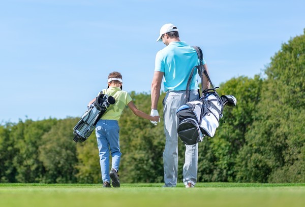 Golfer swinging on a course.